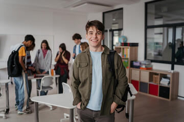 Confident teen student in classroom in school.