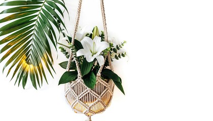 White lilies and greenery in a macrame plant hanger, palm frond