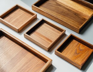 Angled shot of five wooden trays in various shapes and sizes on a surface