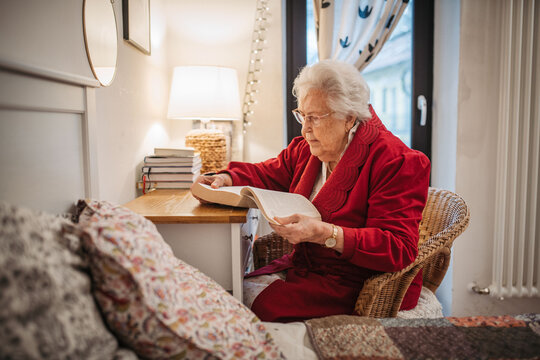 Senior woman relaxing and reading while preparing for sleep.