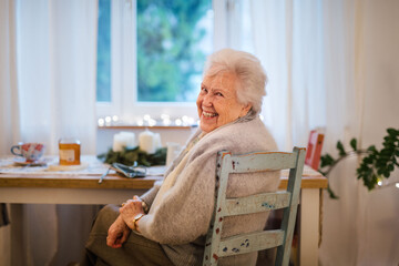 Senior woman smiling warmly on relaxed indoor portrait.