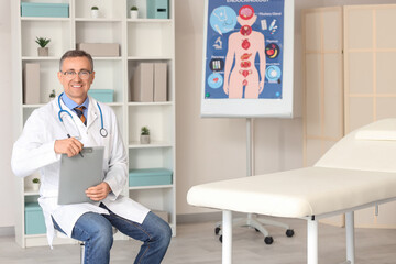 Obraz premium Mature doctor with clipboard in medical office