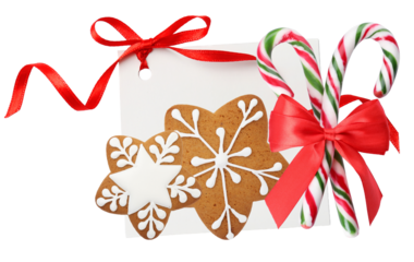 festive christmas arrangement featuring two snowflake-shaped gingerbread cookies, two candy canes, and a blank white card tied with a red ribbon.