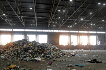Pile of mountains sorting through various types of household waste, including plastics and paper to aid in disposal