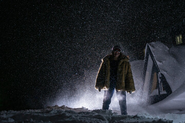 Happy woman on the street at night in snowy weather