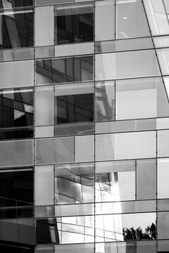 Abstract modern corporate architecture building facade of glass windows with mirrored grid reflections shaping an elegant geometry pattern