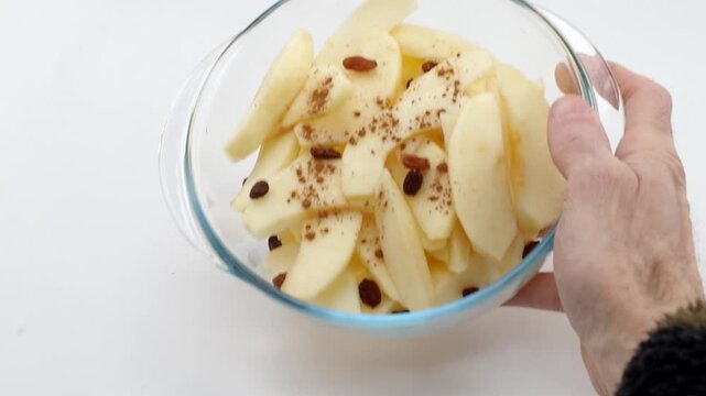 Shot of fresh sliced ​​apples, raisins and cinnamon in a glass bowl