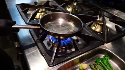 Professional chef flambeing and tossing fresh vegetables in a pan - Powered by Adobe