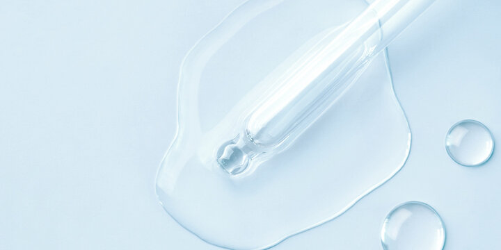 Drop of cosmetics and a pipette on a blue background. A product for skin, face or hair care.