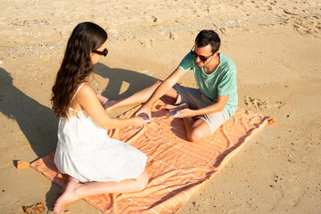 Couple playing a card game on beach vacation