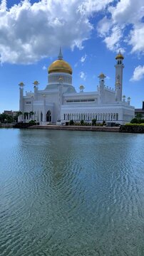 Brunei Darussalam - June 25, 2025: Sultan Omar Ali Saifuddin Mosque in Bandar Seri Begawan. Mosque with reflection in the pond. The mosque's facade and dome are illuminated by sunlight. 4K