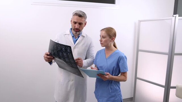 Doctors examining cerebrovascular MRI image of brain during a medical consultation for patient with headaches and dizziness. Magnetic resonance angiography of head