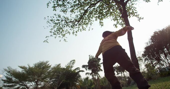 The art of flow, 1000fps slow motion. Graceful Asian traceur performs seamless parkour line, transitioning from run into fluid flip with a beautiful hang time moment. Concept: art flow grace movement