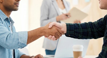 Obraz premium Successful business partnership handshake between a South Asian man and a Caucasian man in a bright office, close up of diverse professionals shaking hands for a deal.