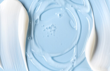 samples of cosmetic care products smear of cream and gel texture on a light blue background, moisturizing and skin care concept