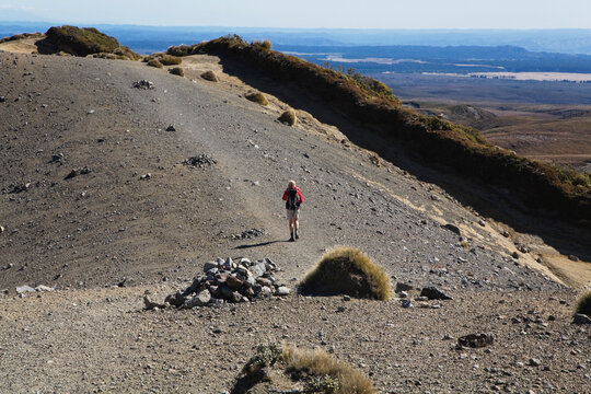 Hiker on Upper Tama Lake Trail Tongariro National Park volcanic moraine landscape