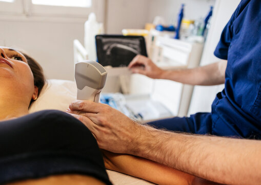 Technician performing ultrasound examination in radiology clinic