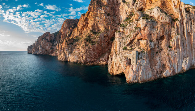 Aerial view of Porto Flavia mining port carved into dramatic limestone cliffs overlooking the Mediterranean Sea in Masua, Sardinia, Italy