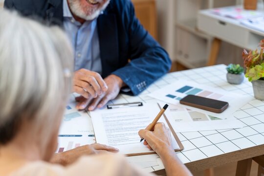 Two people discussing and signing documents in an office meeting