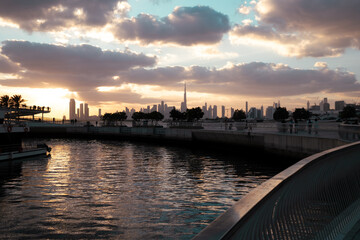 Fototapeta premium Dubai real estate background with dramatic Dubai skyline at sunset, view from Dubai creek harbor