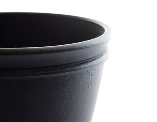 Close-up of a dark, textured flowerpot rim against a bright white background