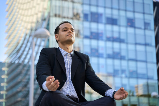 Latin businessman practicing mindfulness meditation outdoors - Powered by Adobe