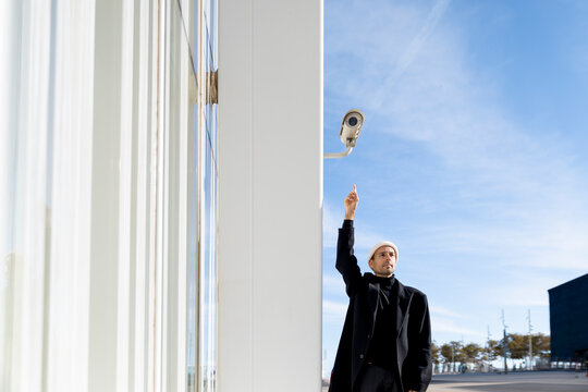 Person in Barcelona pointing at surveillance camera for security awareness