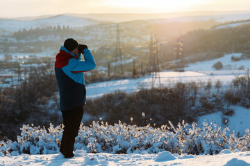 Man traveling, exploring, enjoying the view of the mountains, landscape, lifestyle concept winter vacation outdoors.