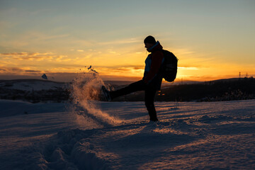 Man having fun in snow covered mountain in magic sunset. Active people in nature, adventure concept