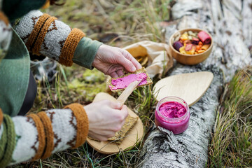 Obraz premium Healthy breakfast in the nature - beetroot pesto, homemade bread and dried fruits