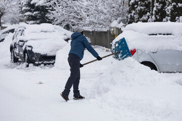 Woman removes snow on the street on a winter morning.