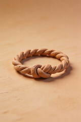 Twisted clay ring with knot detail on beige background  