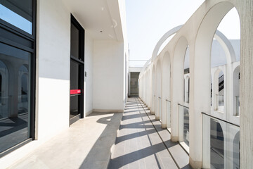 Naklejka premium White arched architectural corridor under blue sky