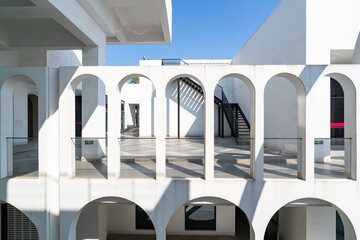 Naklejka premium White arched architectural corridor under blue sky