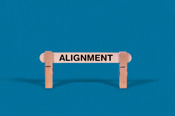 Fototapeta premium Alignment symbol. Single Wooden stick confined by Clothespins, Cool Blue Background. Business and Alignment concept with copy space