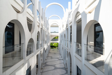 Naklejka premium White arched architectural corridor under blue sky