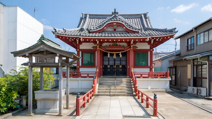 A traditional Japanese temple with a tiled roof and red accents