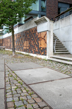 Urban sidewalk pavement entrance with staircase beside wall pattern and texture at sharp angle showing transition and progress in architecture