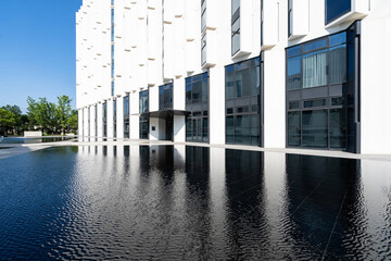 Modern building reflected in black water pool