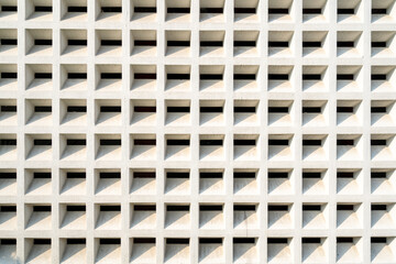 White concrete grid facade with shadow patterns