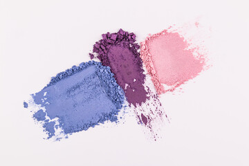 Three beautiful eye shadow strokes of different colors on a white background. blue, purple and pink eye shadow samples. Texture decorative cosmetics