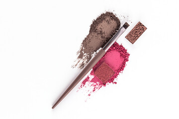 Two cosmetic eyeshadow texture swatches in pink and brown on a white background with a brown eyeshadow refill and professional makeup brush. top view.