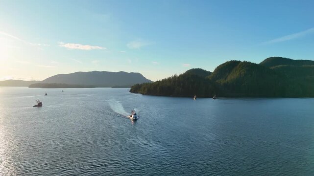Aerial view of boats sailing on the sea, the lush green forested islands contrast with the blue water and clear sky, Sitka, Alaska, United States.