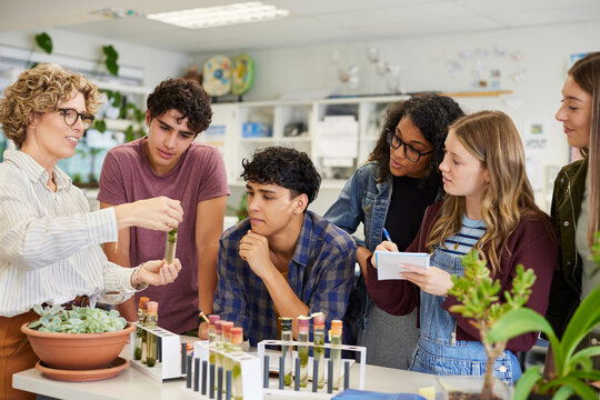 Teacher showing science experiment to class at high school