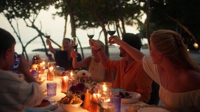Family and friends enjoying a beautiful toast during dinner on a tropical island