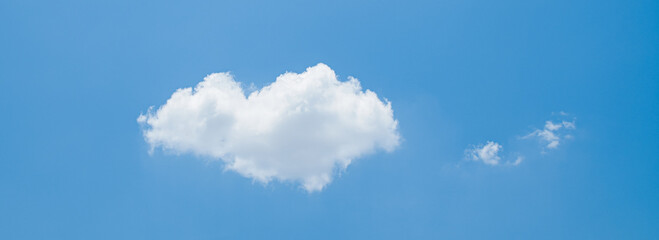 the sky is filled with fluffy white clouds and bright sunlight, beautiful and sunny. the background is blue with no one around.