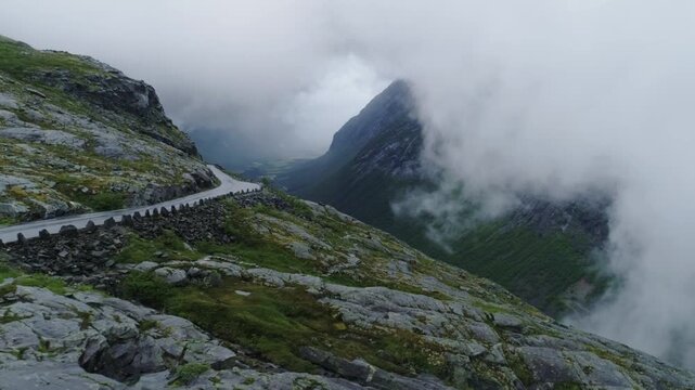 Moody weather, dramatic Norwegian mountains as river flows Trollstigen viewpoint
