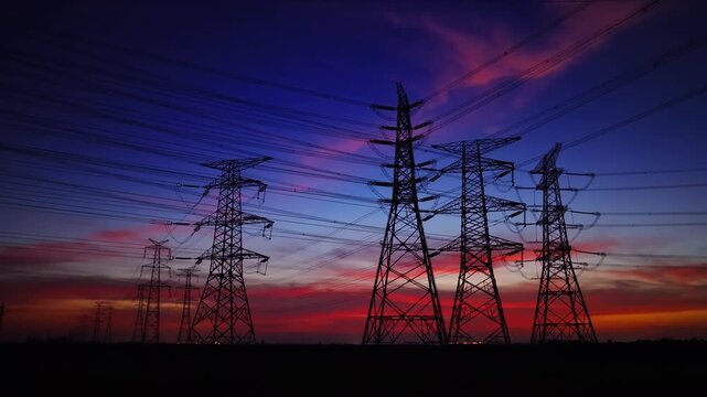 High voltage power tower and sky clouds background at night