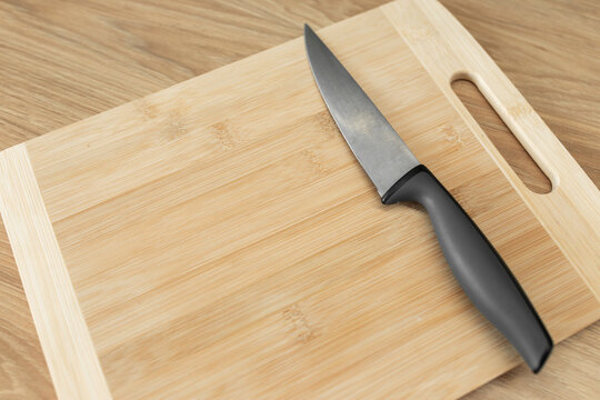 Sharp stainless steel kitchen knife resting on a wooden cutting board.