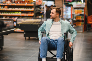 Customer using wheelchair choosing groceries in supermarket